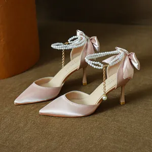 Elegant pink satin pointed toe high heels with pearl ankle strap and silk bow detail.