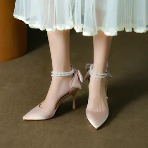 Elegant satin pointed toe high heels with bow back and pearl ankle straps.