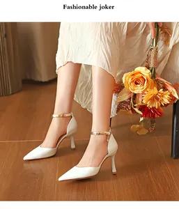 Elegante weiße spitze High Heel Pumps mit dekorativen goldenen Knöchelriemen am Modell