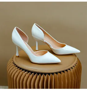 Vue détaillée d'escarpins d'Orsay en cuir verni blanc à bouts pointus et talons aiguilles.
