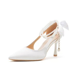 Elegant white bridal high heels with pearl strap and bow detail for wedding ceremony