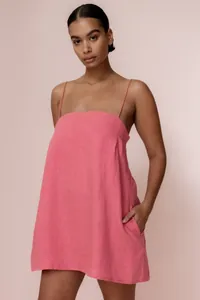 Detailed view of a stylish pink linen spaghetti strap mini dress with functional pockets