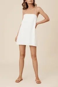 Chic white cotton linen mini dress with thin straps for a comfortable vacation look