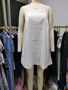 Macro detail of a minimalist white cotton linen camisole dress on a tailor mannequin