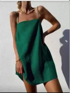 Vue détaillée d'une robe nuisette bohème en coton et lin vert sous le soleil d'été