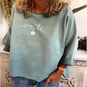Vue détaillée en gros plan d'un haut pour femme vert menthe avec motif Smile et étoile