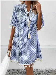 Detailed close-up view of bohemian blue printed dress with V-neck and white tassel trim detail