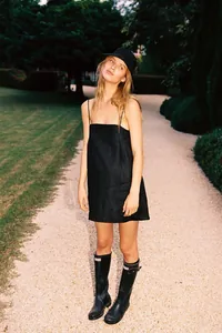 Vue extérieure d'une robe nuisette en lin noir portée par un mannequin dans un jardin.