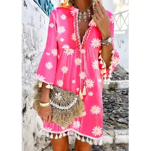 Robe bohème rose à imprimé marguerites avec col en V et détails de glands sur l'ourlet