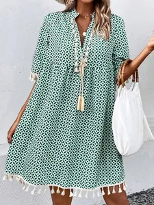 Detail view of green bohemian V-neck dress with tassels and geometric print