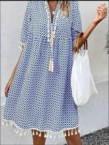 Detail view of blue bohemian printed V-neck dress with decorative white tassels