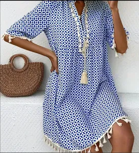 Detailed macro shot of bohemian blue white geometric print dress featuring white tassels