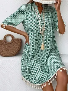 Green geometric print Bohemian dress with V-neck and tassel details for summer wear.