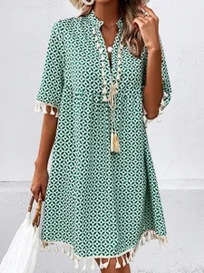 Bohemian V-neck summer dress with green geometric print and tassel hem details