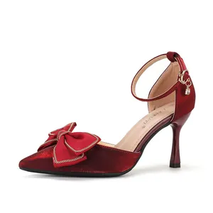 Detail der weinroten Stilettos mit spitzer Zehenpartie, Schleife und Fesselriemen