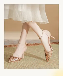 Close-up shot of elegant champagne sequined stiletto heels with ankle strap design