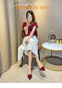 Close-up of elegant burgundy patent leather pointed-toe heels with chain detail