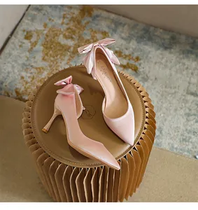 Eleganti tacchi a spillo in raso rosa con punta stretta, fiocco posteriore e design traforato.
