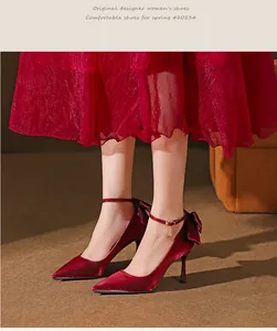 Elegante Nahaufnahme roter Seidenpumps mit Knöchelriemen und dekorativem Schleifendetail