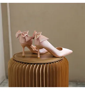 Eleganti décolleté a spillo in raso rosa con apertura laterale e fiocco sul tallone.