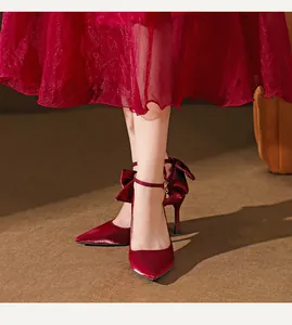 Detailansicht eleganter weinroter Seidenpumps mit spitzer Kappe und Schleifen-Knöchelriemen