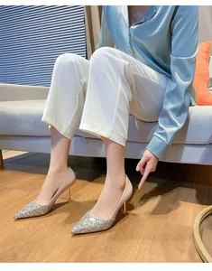 Escarpins élégants à bouts pointus pailletés portés par un mannequin dans un salon.