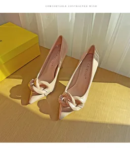 Detail showing nude patent leather stilettos with elegant chain ornament