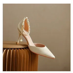 Elegante champagnerfarbene Satin-Pumps mit Perlen-Knöchelriemen auf Hocker