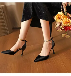 Elegante schwarze spitze Stilettos mit einzigartigem goldenen Metall-Knöchelriemen