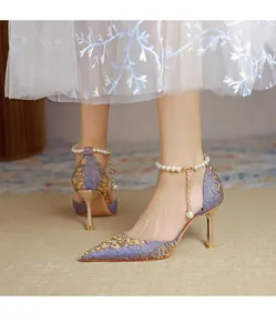 Detail view of purple and gold pointed-toe high heels with pearl ankle strap