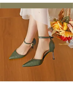 Detail of elegant green crocodile-embossed pointed toe d'Orsay heels with ankle strap.