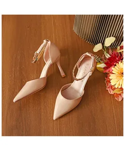 Detailansicht der beigen Stöckelschuhe mit spitzer Zehenpartie und eleganter Goldkette