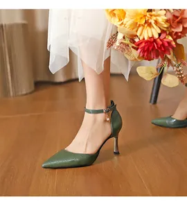 Close-up of elegant dark green crocodile pattern pointed toe pumps with an ankle strap