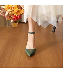 Elegant green crocodile pattern pointed-toe high heel shoes worn with a white skirt