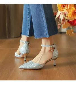 Vista lateral de zapatos de tacón bajo con purpurina plateada y pulsera al tobillo.