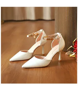Elegante weiße spitze Sandalen mit hohen Absätzen und goldfarbenen Knöchelriemen