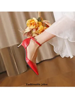 Detail view of red crocodile pattern pointed-toe stiletto heels with ankle strap.