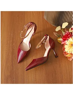 Nahaufnahme von weinroten Stöckelschuhen mit eleganten Knöchelriemen und Goldschnalle.