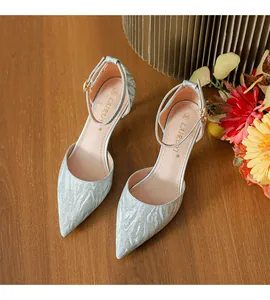 Detalle de elegantes zapatos de tacón con purpurina plateada, punta fina y correa al tobillo