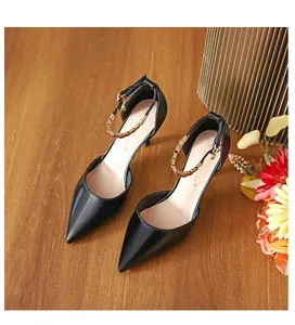 Elegante schwarze spitze Stilettos mit goldenem Metallketten-Knöchelriemen-Detail.