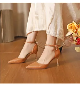 Macro view of brown crocodile embossed pointed-toe stiletto heels with elegant ankle straps