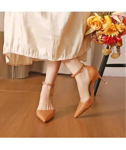 Elegant brown crocodile pattern pointed-toe pumps with ankle straps shown on a model