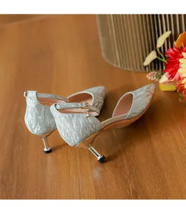 Primer plano de zapatos de tacón bajo con purpurina plateada y colgante en el tobillo