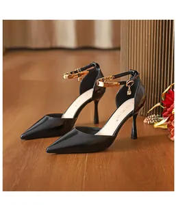 Elegante Seitenansicht schwarzer Lackleder-Stilettos mit spitzer Kappe und goldenen Riemchen