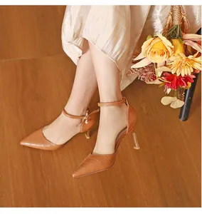 Close-up detail of tan croc-embossed pointed toe high heels with elegant ankle straps