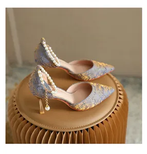 Detail of blue textured pointed toe pumps with elegant pearl ankle strap decoration