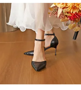 Detailed view of elegant black crocodile-embossed pointed-toe high heels with ankle strap.