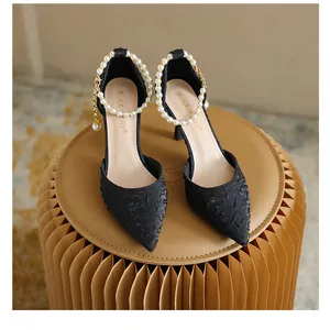 Elegant black pointed toe stiletto high heels featuring a luxury pearl ankle strap detail