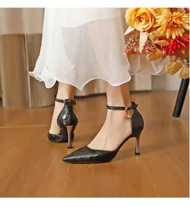 Detail view of black crocodile embossed stiletto pumps with elegant ankle strap charm