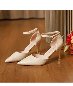 Detail view of beige crocodile pattern high heel sandals with crystal ankle strap charm